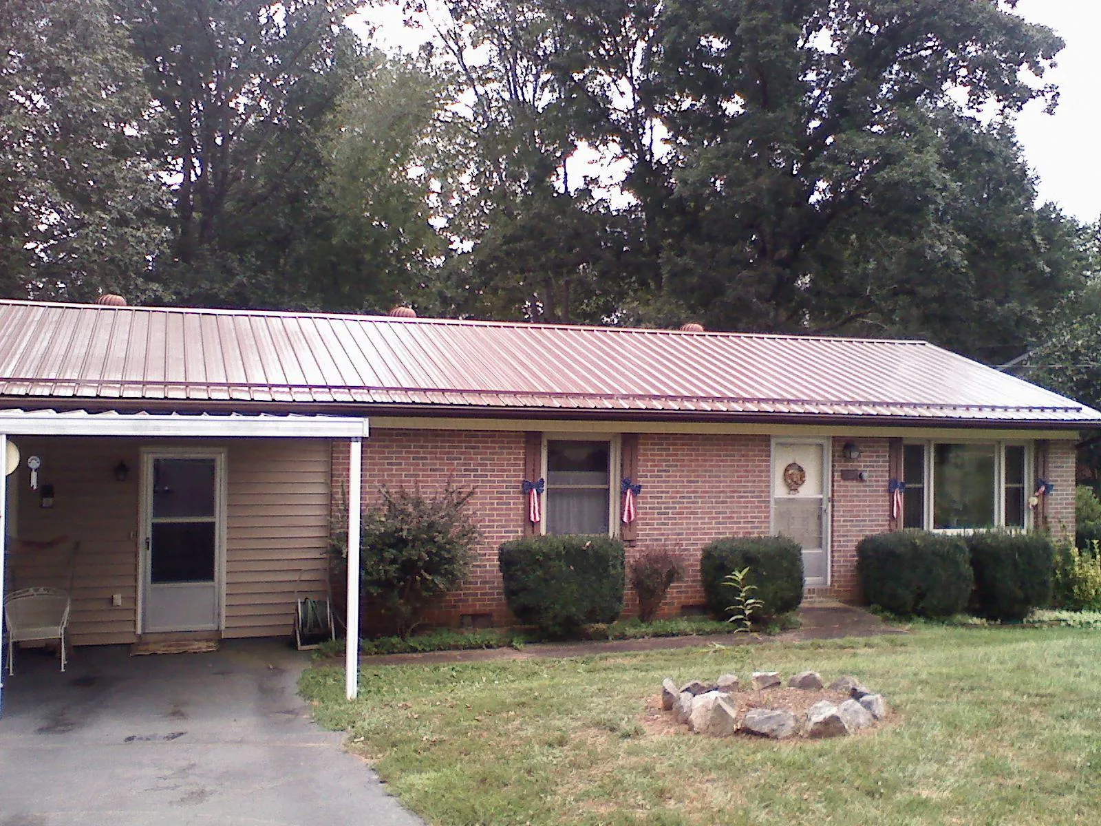 Bronze metal roof and carport on a brick ranch home — Roof Repair work by our crew in Lancaster